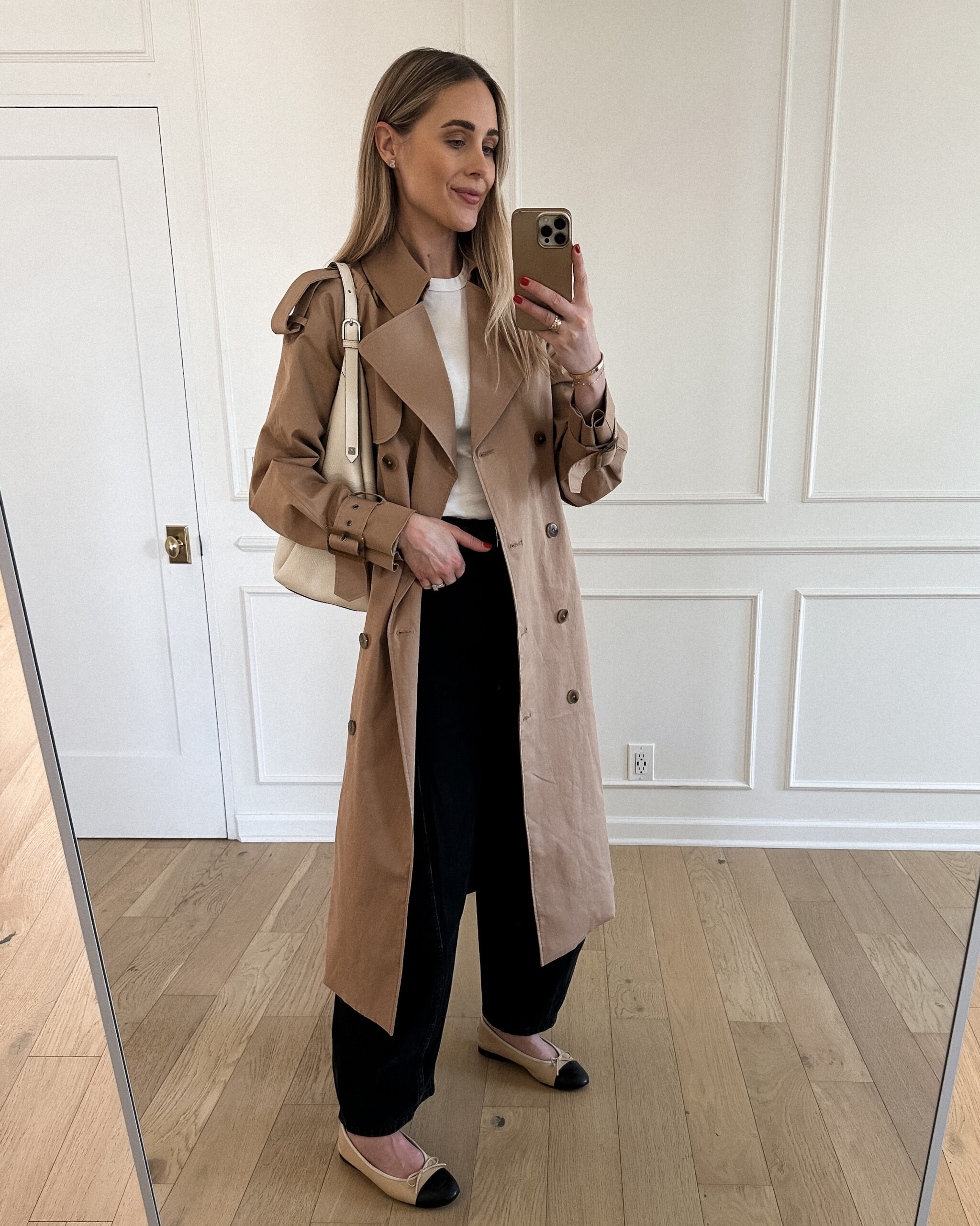 Fashion Jackson Wearing Mayson the label long trench coat, white tshirt, black tibi horseshoe jeans, chanel beige ballerina flats, toteme white hobo bag