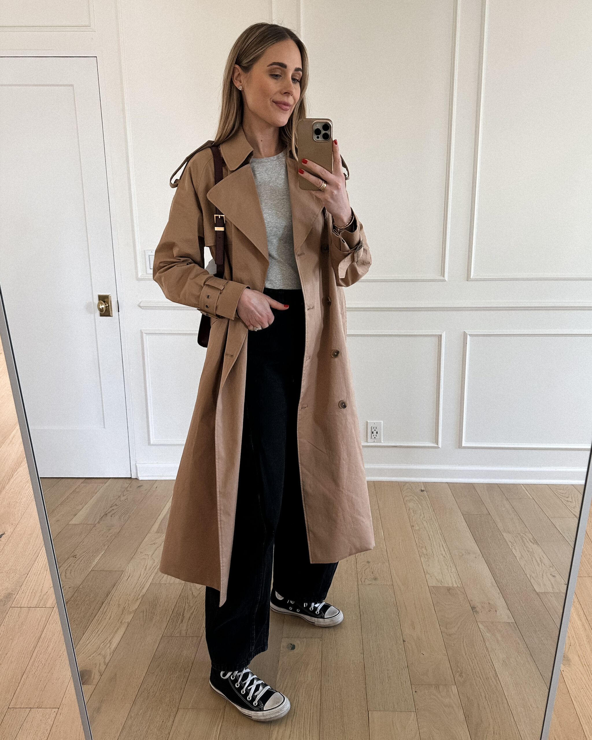 Fashion Jackson Wearing Mayson the label long trench coat, grey long sleeve tee, tibi black horseshoe jeans, black converse high top sneakers