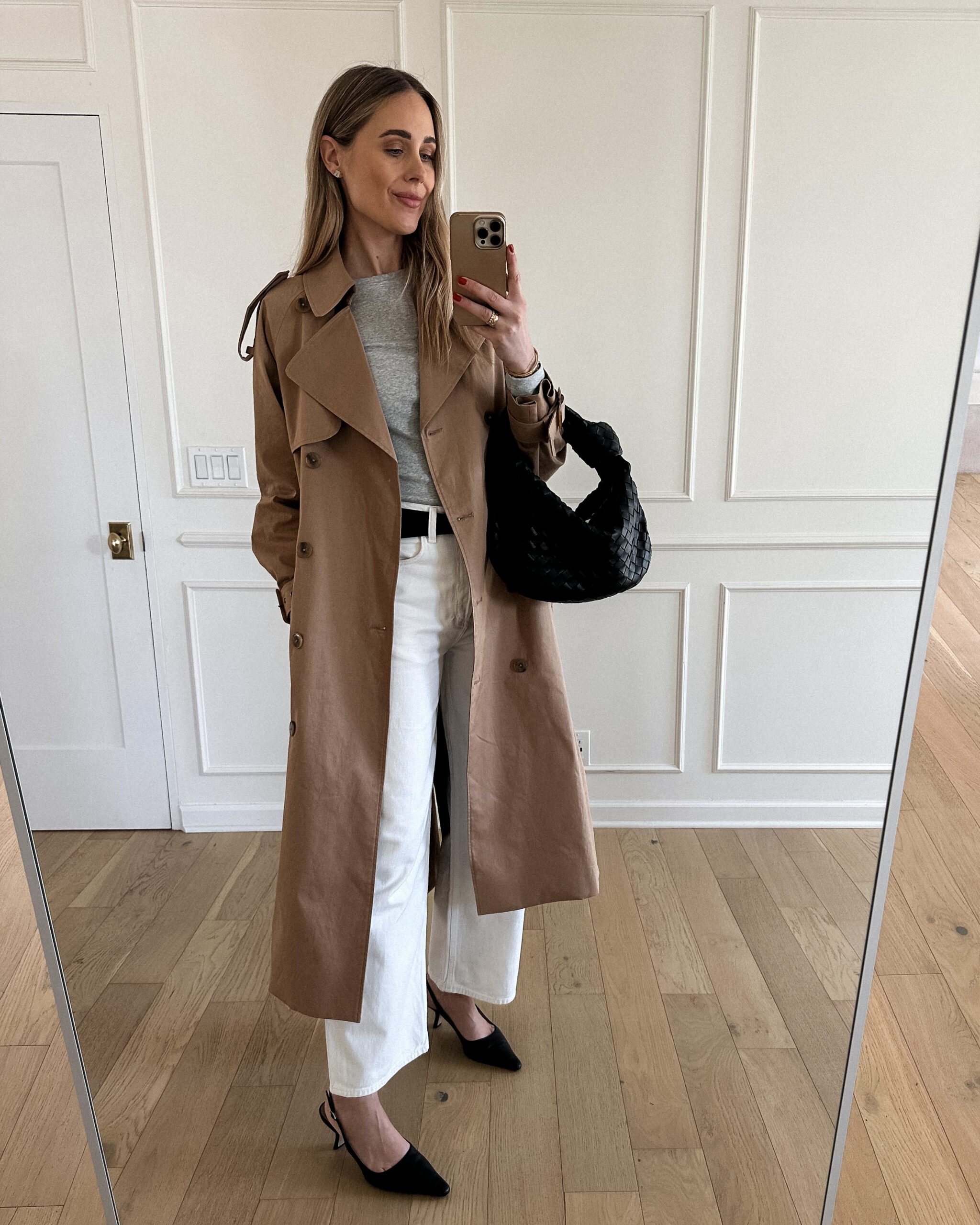 Fashion Jackson Wearing Mayson the label long trench coat, grey long sleeve tee, white agolde jeans, black slingbacks, bottega veneta black teen jodie